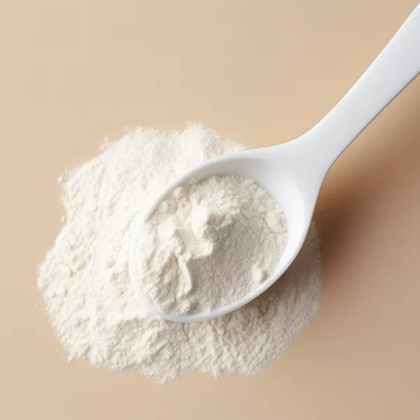 A white plastic spoon rests on a small pile of fine white powder on a beige surface.