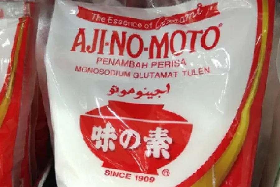 A close-up of a package of AJI-NO-MOTO monosodium glutamate seasoning with text in multiple languages on the front.