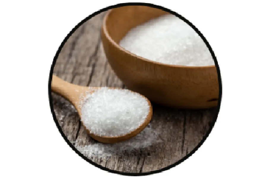 A wooden spoon with white granulated sugar, next to a wooden bowl filled with sugar, on a rustic wooden surface.