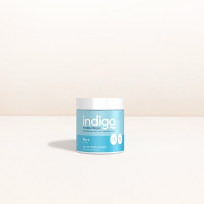 A light blue container of Indigo Collagen "Pure" dietary supplement sits on a plain, neutral surface with a simple beige background.