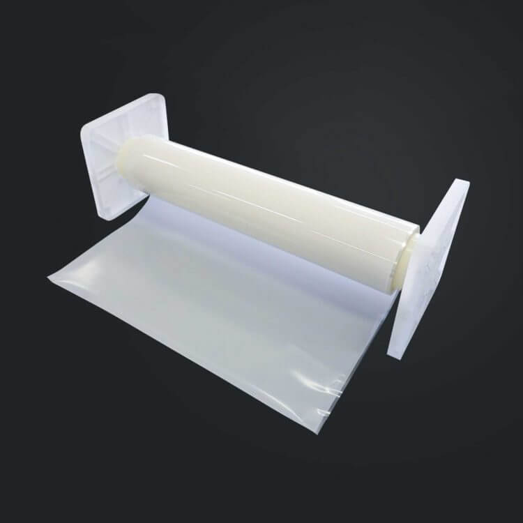 A transparent plastic film roll with protective end caps, partially unrolled, placed on a dark background.