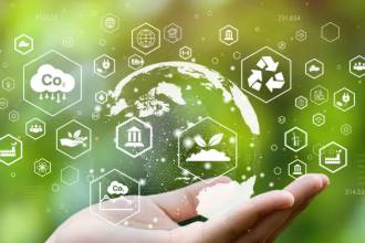 A hand holds a transparent globe, surrounded by environmental icons, including CO2, recycling, and renewable energy, against a blurred green background.