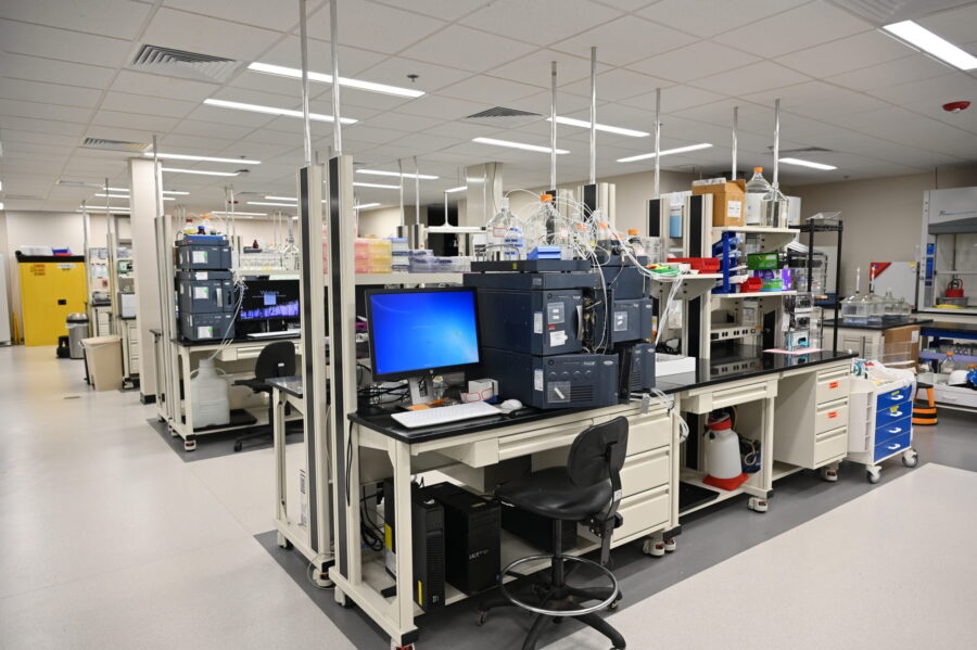 A modern laboratory with analytical instruments, computers, workstations, and lab equipment arranged on benches in a clean, organized workspace.