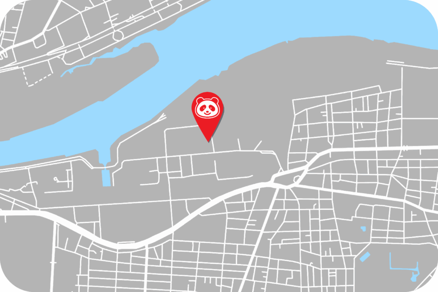A digital map with a river and streets, featuring a red location pin with a panda face icon marking a specific spot near the river.