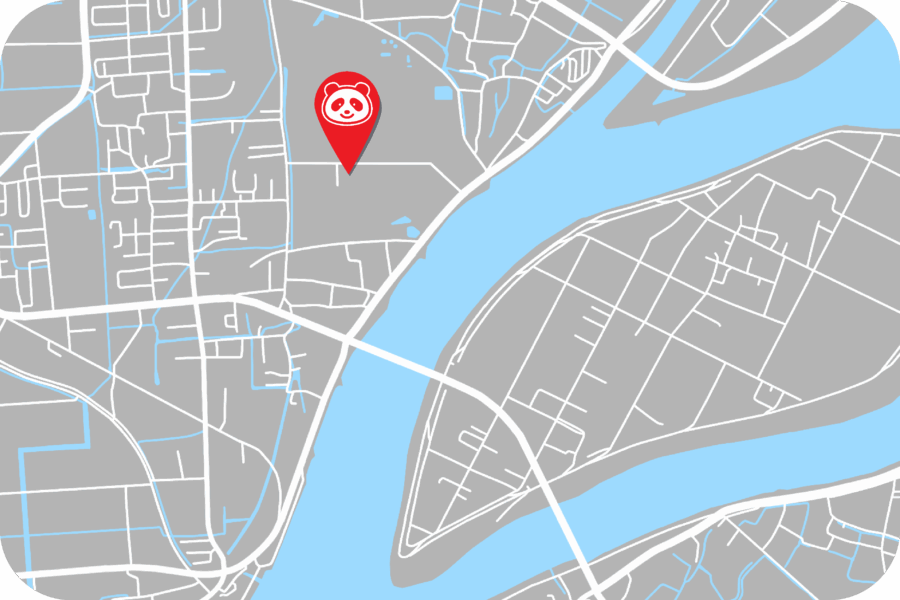 A gray city map with a river, showing a red location pin featuring a panda icon placed near the riverbank on the left side of the map.