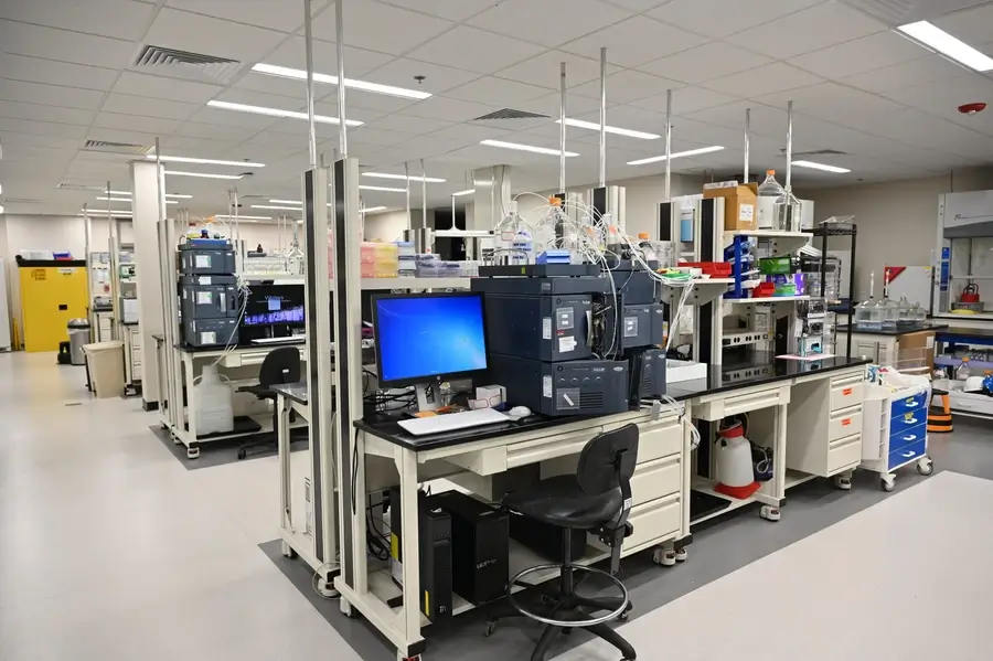 A modern laboratory with analytical instruments, computers, workstations, and lab equipment arranged on benches in a clean, organized workspace.