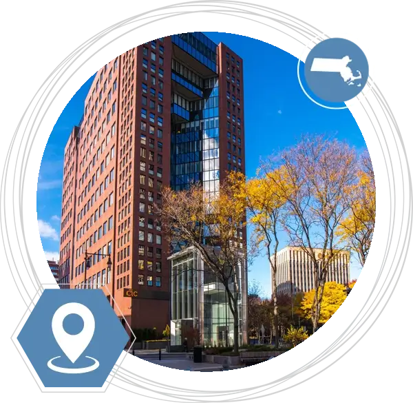 The outside of the building at the Cambridge, MA location in a circle with a pin icon and and icon of the state of Massachusetts.
